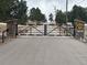 Private ranch entrance with a gated driveway and stone pillar features at 4948 Cameyo Rd, Indian Hills, CO 80454