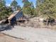A modern A-frame home with a spacious deck, inviting hot tub, and picturesque hillside setting surrounded by trees at 4948 Cameyo Rd, Indian Hills, CO 80454