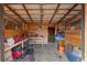 Interior of a wood-paneled stable featuring a workbench, storage, and equipment at 4948 Cameyo Rd, Indian Hills, CO 80454