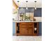 Close-up of a kitchen island with seating, wooden cabinets and drawers, and pendant lighting at 4948 Cameyo Rd, Indian Hills, CO 80454