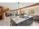 Large kitchen island with marble countertops, stainless appliances and gas cooktop at 4948 Cameyo Rd, Indian Hills, CO 80454
