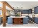 Open kitchen featuring blue cabinets, a large center island, and stainless steel appliances at 4948 Cameyo Rd, Indian Hills, CO 80454