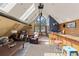 A-frame living room featuring a stylish bar and large windows with natural light at 4948 Cameyo Rd, Indian Hills, CO 80454