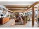 Bright living room featuring a stone fireplace, exposed beams, and large windows with natural light at 4948 Cameyo Rd, Indian Hills, CO 80454