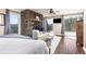 Inviting main bedroom features stone fireplace, hardwood floors, with a view out to the deck at 4948 Cameyo Rd, Indian Hills, CO 80454