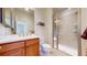 Bright bathroom featuring a tiled walk-in shower and a wooden vanity at 8199 W 67Th Ave, Arvada, CO 80004