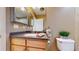Bathroom featuring a toilet and vanity with granite counters, wood cabinets, and two mirrors at 8199 W 67Th Ave, Arvada, CO 80004