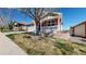 Beautifully landscaped front yard with a brick home and covered porch at 8199 W 67Th Ave, Arvada, CO 80004