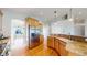 Well-lit kitchen showcases a stainless steel fridge, granite countertops, hardwood floors, and ample cabinet space for optimal storage at 8199 W 67Th Ave, Arvada, CO 80004