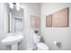 This half bathroom has a sink with faucet, a toilet, and modern décor at 3879 N Shawnee St, Aurora, CO 80019