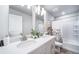 Bright bathroom featuring double sinks, white countertops, and a shower-tub combo at 3879 N Shawnee St, Aurora, CO 80019