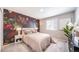 Floral accent wall with primary bedroom set, neutral walls, and carpeted floors at 3879 N Shawnee St, Aurora, CO 80019