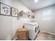 This laundry room includes a washer, dryer, and shelving space at 3879 N Shawnee St, Aurora, CO 80019