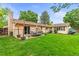 Lush backyard with a patio, furniture and an umbrella, offering a perfect setting for outdoor relaxation and entertainment at 7442 S Wellington St, Centennial, CO 80122