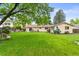 Expansive backyard featuring a well-manicured lawn, mature trees, and outdoor seating, ideal for recreation and relaxation at 7442 S Wellington St, Centennial, CO 80122