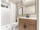 Modern bathroom with a shower, a vanity with a wooden cabinet and a sink, and a toilet at 7442 S Wellington St, Centennial, CO 80122
