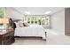 Bright bedroom featuring a large window and a dark wood sleigh bed with white bedding at 7442 S Wellington St, Centennial, CO 80122