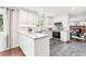 Bright kitchen boasts stainless appliances, gray tile floors, and white cabinets and countertops at 7442 S Wellington St, Centennial, CO 80122