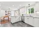 Modern kitchen featuring stainless steel appliances, white cabinetry, and stone countertops at 7442 S Wellington St, Centennial, CO 80122