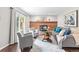 Brick fireplace highlights this living room with hardwood floors, ample seating, and natural light at 7442 S Wellington St, Centennial, CO 80122