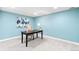 Bright office with a desk, chair, and modern artwork, offering a comfortable workspace with neutral carpet and light blue walls at 7442 S Wellington St, Centennial, CO 80122