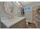 Elegant bathroom featuring a double sink vanity with marble countertops, stylish mirrors, and modern fixtures at 7541 Julian St, Westminster, CO 80030