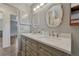 Elegant bathroom features a double sink vanity with marble countertops, stylish mirrors, and open doorway at 7541 Julian St, Westminster, CO 80030