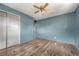 Light blue bedroom with wood-look floors, a ceiling fan, and closet at 7541 Julian St, Westminster, CO 80030