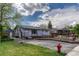 Charming single-story home featuring a well-maintained lawn and a welcoming front porch with solar panels above at 7541 Julian St, Westminster, CO 80030