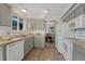 Bright kitchen with white appliances, gray cabinets, wood-look floors and a view to dining room at 7541 Julian St, Westminster, CO 80030