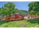 Relaxing backyard features a charming deck with outdoor seating and mature trees at 6085 S Parfet St, Littleton, CO 80127