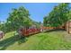 Landscaped backyard with a wooden deck, mature trees, and privacy fencing at 6085 S Parfet St, Littleton, CO 80127