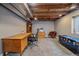 Finished basement area showcasing a wooden desk, office chair, and exposed beams, offering a versatile space at 6085 S Parfet St, Littleton, CO 80127