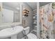 Bathroom featuring a pedestal sink, mirror, toilet, and patterned shower curtain at 6085 S Parfet St, Littleton, CO 80127