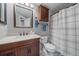 Bathroom features a vanity with a marble countertop, wood cabinet, and a mirror and a shower with a patterned shower curtain at 6085 S Parfet St, Littleton, CO 80127