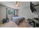 Bedroom featuring gray walls, a ceiling fan, a window with a view of trees, and a bed with a gray and brown blanket at 6085 S Parfet St, Littleton, CO 80127