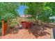 Exterior deck with a patio furniture set, a table, and a wooden fence surrounded by mature trees at 6085 S Parfet St, Littleton, CO 80127