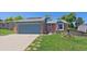 Charming single-story home with an attached garage, red brick accents, and lush green lawn at 6085 S Parfet St, Littleton, CO 80127