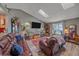 Bright living room showcasing a vaulted ceiling, skylight, comfortable seating, and views of the outdoors at 6085 S Parfet St, Littleton, CO 80127
