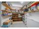 Organized pantry room with wooden shelves stocked with food items and a white deep freezer at 6085 S Parfet St, Littleton, CO 80127