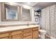 Well-lit bathroom featuring wood vanity, dual mirrors, and shower curtain at 4856 E Hinsdale Pl, Centennial, CO 80122