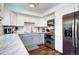 Well-lit kitchen featuring white cabinets, gray lower cabinets, and stainless steel appliances at 4856 E Hinsdale Pl, Centennial, CO 80122