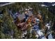 Stunning aerial view of a luxury home nestled in a wooded mountain setting at 9308 Fallen Rock Rd, Conifer, CO 80433