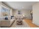 Bright and airy living room featuring hardwood floors, stylish decor, and a large window offering picturesque views at 9598 Lou Dr, Northglenn, CO 80260