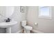 This is a half-bathroom featuring a pedestal sink, white toilet, and natural light from the window above at 6558 Kenzie Cir, Castle Pines, CO 80108