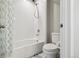 A bathroom includes a tub with a shower curtain and a toilet, creating a functional space at 6558 Kenzie Cir, Castle Pines, CO 80108