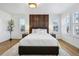 This bedroom features a wooden headboard, natural light from two windows, and hardwood flooring at 6558 Kenzie Cir, Castle Pines, CO 80108