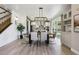 Bright dining room features a modern light fixture, wood floors, and seamless flow into the kitchen at 6558 Kenzie Cir, Castle Pines, CO 80108