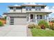 Charming two-story home with stone accents, a modern garage door, and landscaped front yard at 6558 Kenzie Cir, Castle Pines, CO 80108