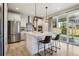 Bright, white kitchen with stainless steel appliances, large island with seating, and backyard view at 6558 Kenzie Cir, Castle Pines, CO 80108